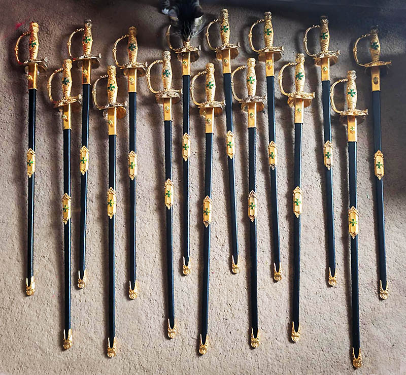 A dozen ceremonial swords with gold hilts and scabbards